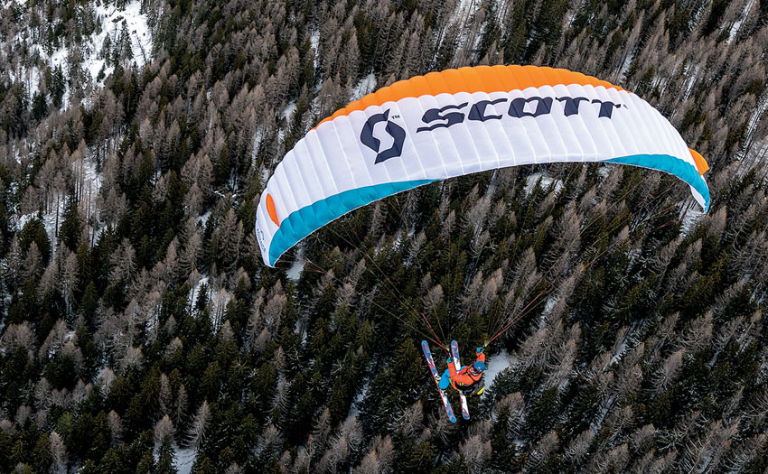 Paragliding with skis above trees, by Andi Busslinger