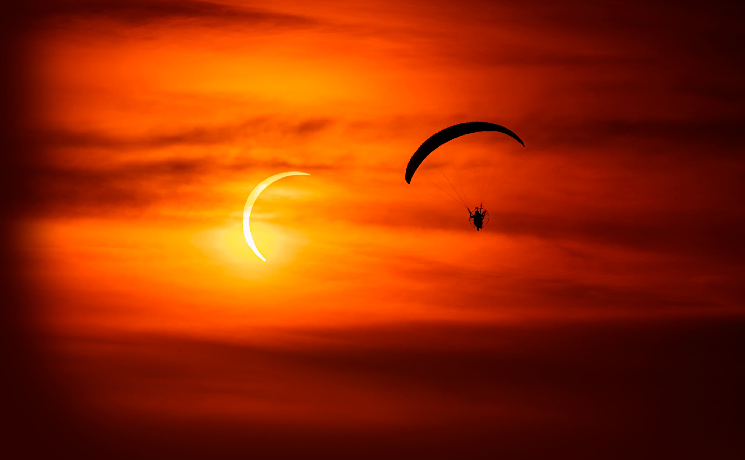 Horacio Llorens flies in front of the eclipse